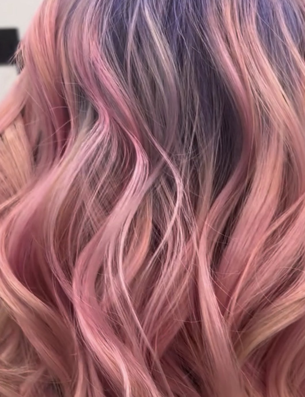 Pastel pink and lavender blended vivid hair color with loose waves