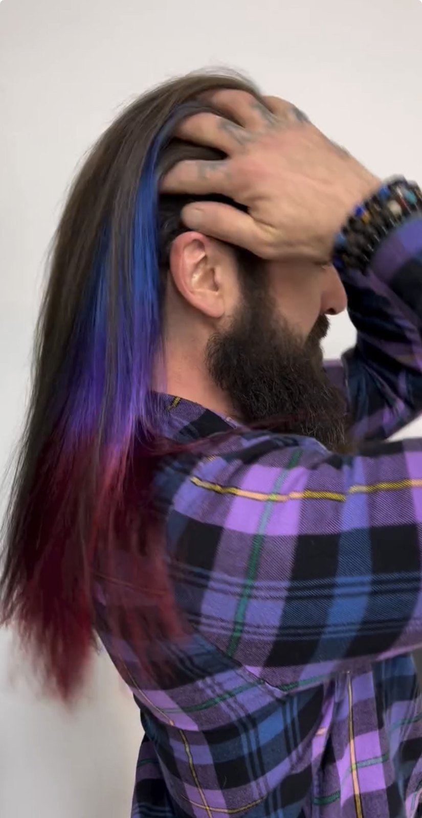 Hidden purple and magenta peek-a-boo underlights beneath dark natural hair